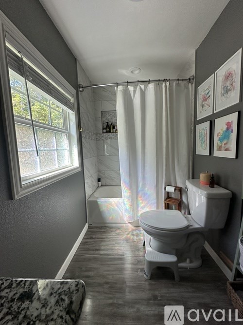 A bathroom with a toilet, sink, and shower.