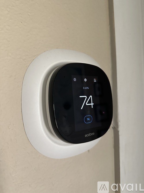 A wall-mounted thermostat displays a temperature of 74 degrees.