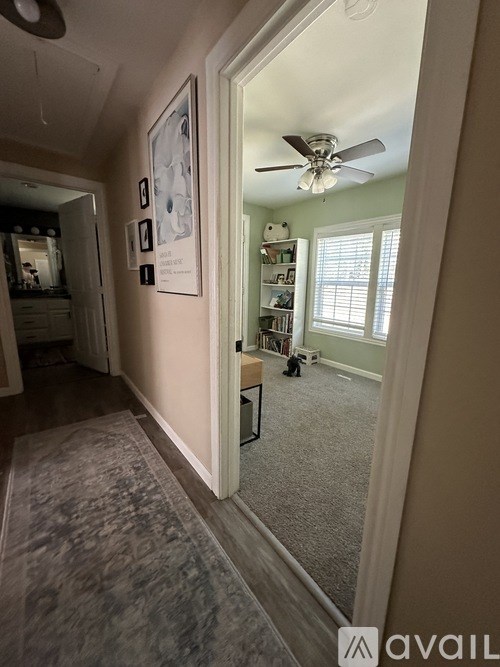 A room with a ceiling fan and a carpeted floor.