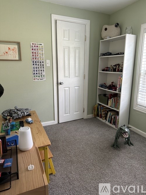 A room with a white door and a bookshelf filled with books.