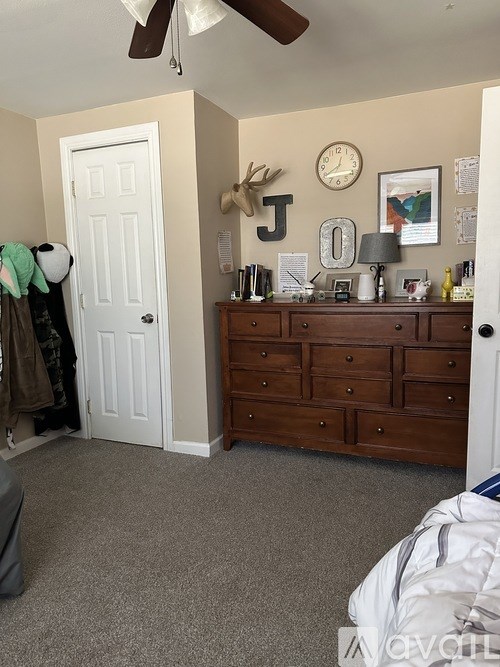 A bedroom with a dresser and a white door.