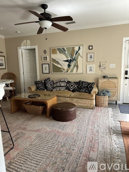 A living room with a couch, coffee table, and pictures on the wall.