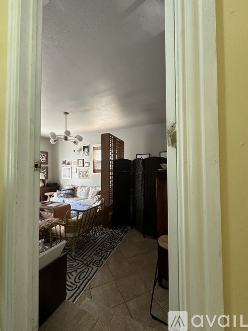 A room with a dining table and chairs is visible through a doorway.