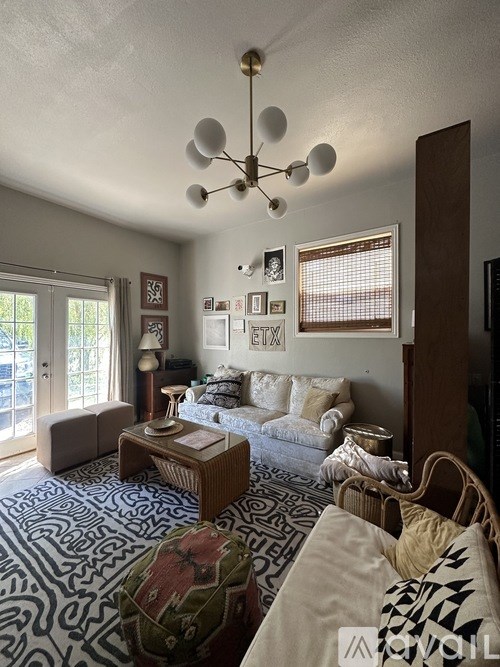 A living room with a white couch and a patterned rug.