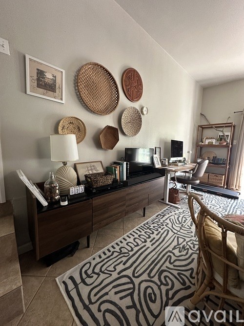 A living room with a black and white patterned rug on the floor.