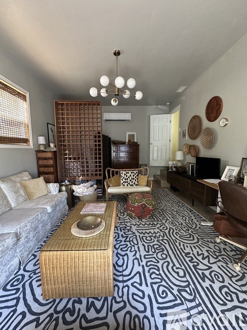 A living room with a patterned carpet and a wooden coffee table.