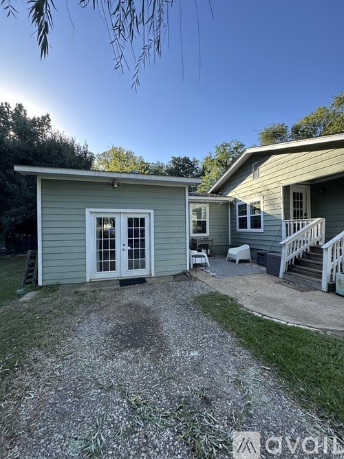 A small house with a white door and a porch.