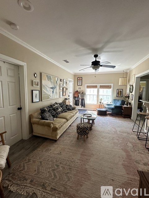 A living room with a beige couch and a rug.