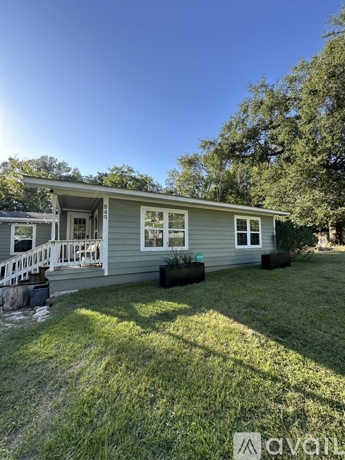 A house with a grey exterior and a white porch.