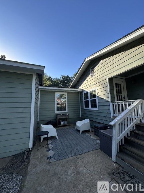 A house with a grey siding and a white door is shown.