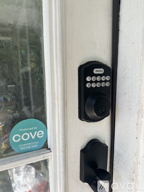 A door handle with a keypad and a sticker that says "Protected by Cove".