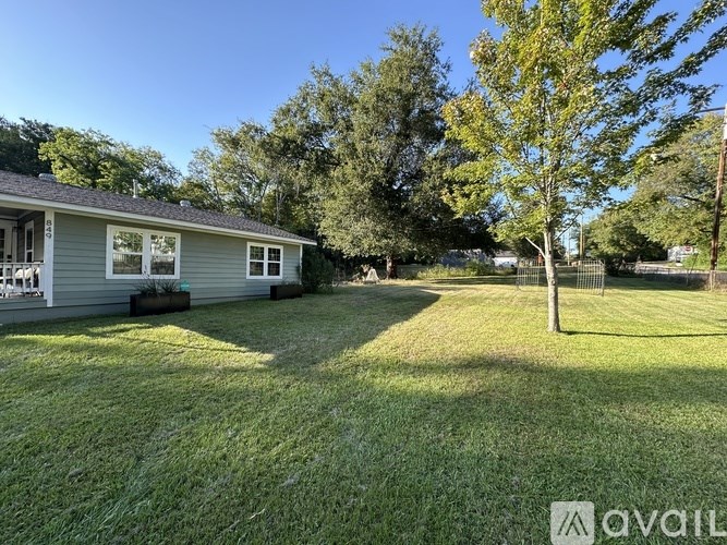 A house with a lawn and trees in the background.