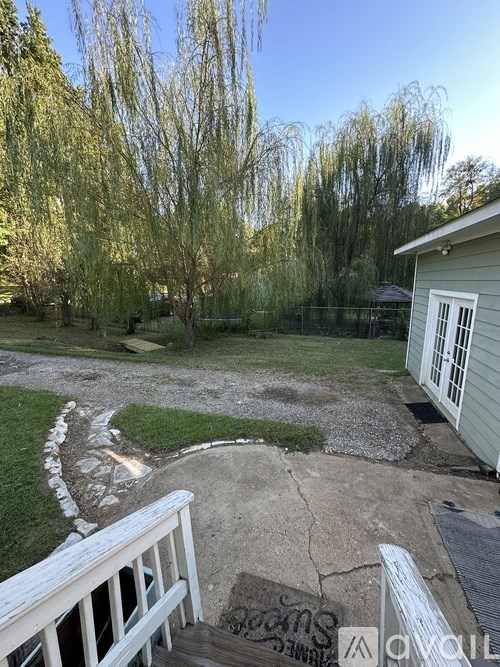 A backyard with a white fence and a small shed.