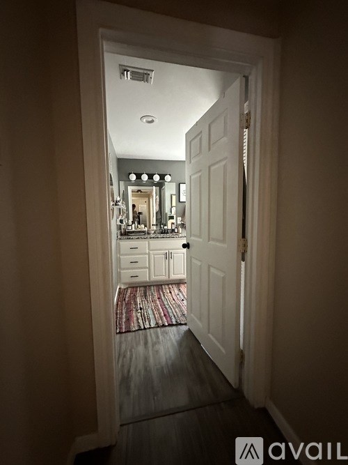 A hallway with a doorway leading to a bathroom.