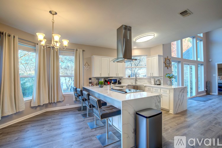 A modern kitchen with a large island and a chandelier.