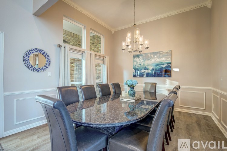 A dining room with a large table and chairs.
