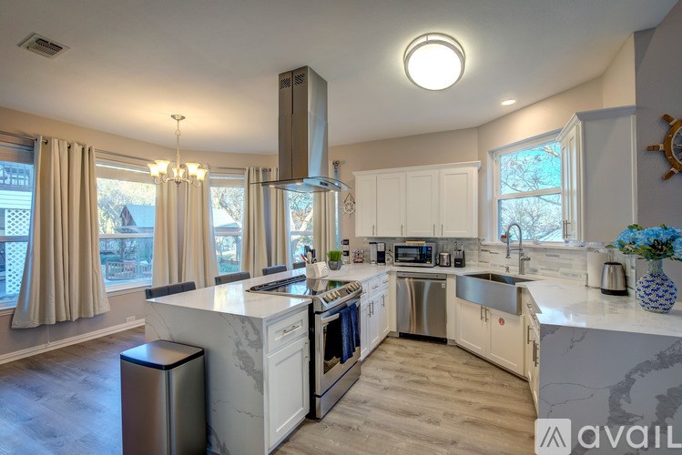 A modern kitchen with a large island and stainless steel appliances.