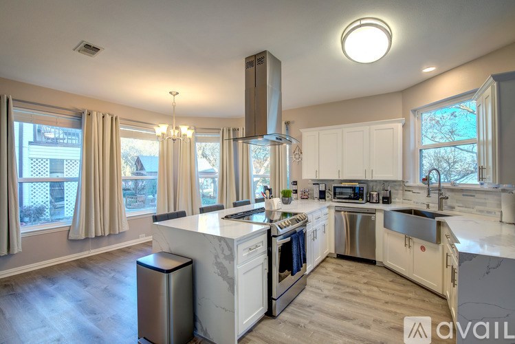 A modern kitchen with a large island and stainless steel appliances.