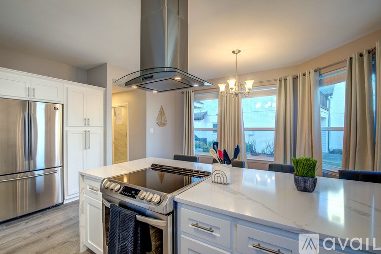 A modern kitchen with a stainless steel refrigerator and a white countertop.