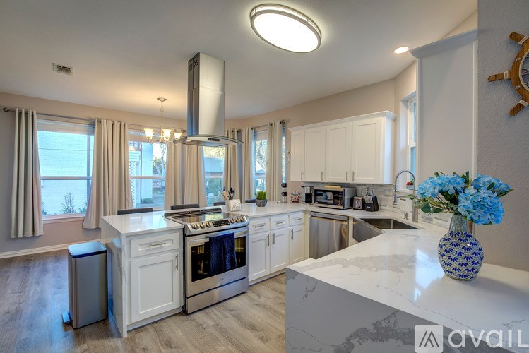 A kitchen with a white countertop and a vase of blue flowers on it.