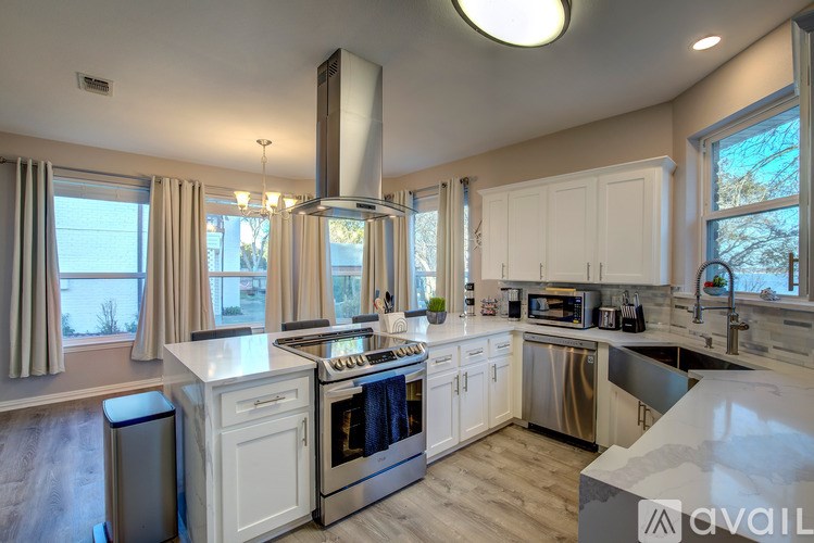 A modern kitchen with a large island and stainless steel appliances.