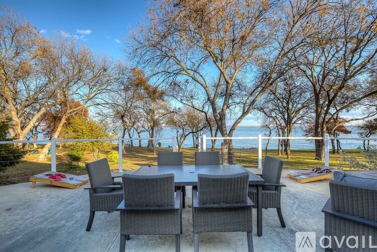 A patio with a table and chairs overlooking the sea.