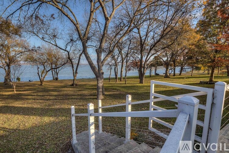 A white fence leads down to a body of water.