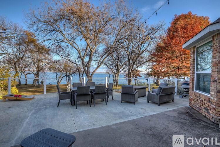 A patio with a table and chairs overlooking a body of water.