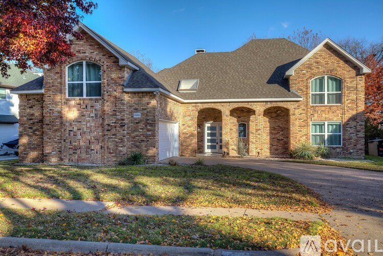 A house with a stone facade and a white garage door is for sale.