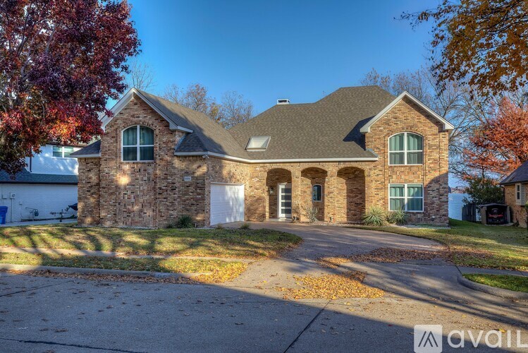 A house with a stone facade and a large front yard.
