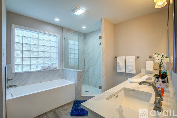 A bathroom with a white tub and sink.