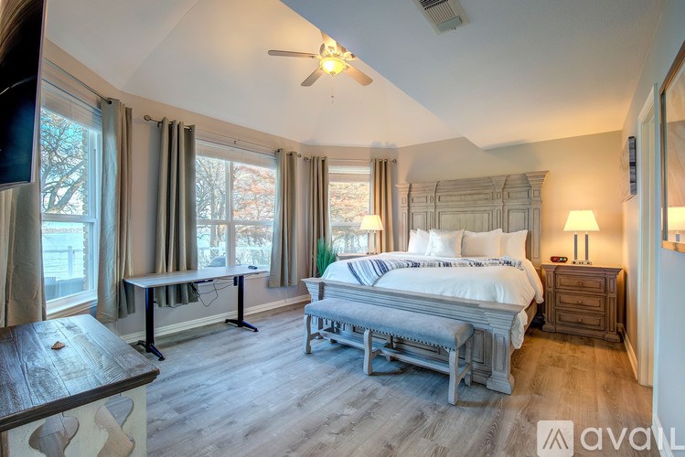 A bedroom with a large bed and a wooden table.