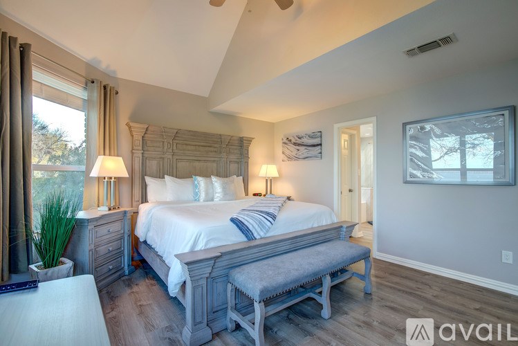 A bedroom with a large bed and a bench in front of it.