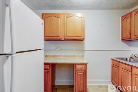 A kitchen with wooden cabinets and a white refrigerator.