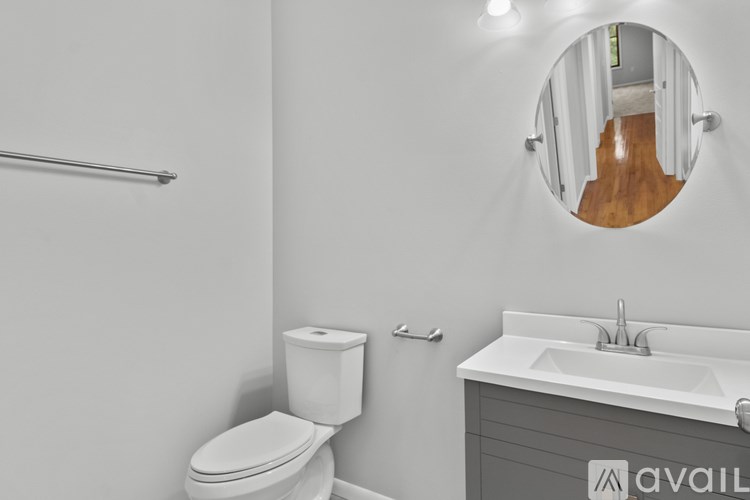 A bathroom with a toilet, sink, and mirror.