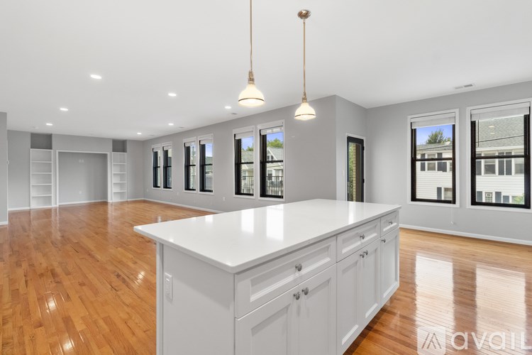 A kitchen with white cabinets and a wooden floor.