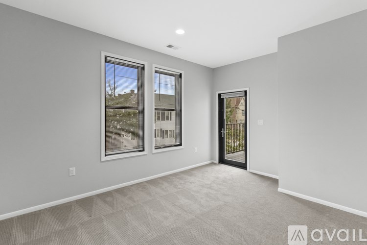 A room with a carpeted floor and a large window with a view of a building.
