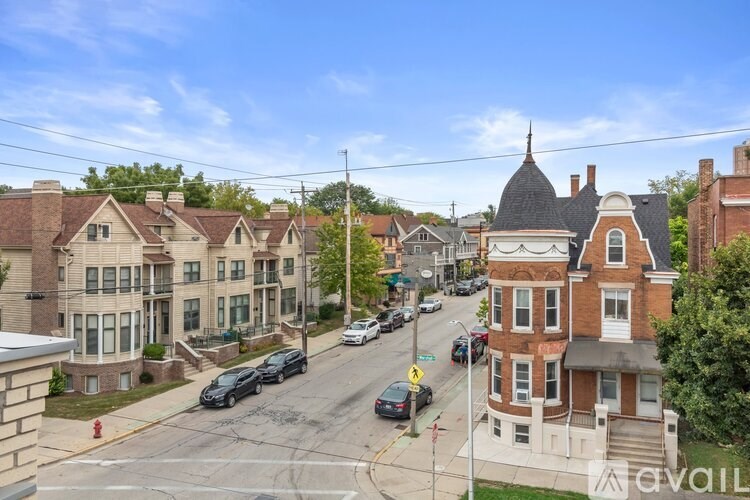 A street view of a residential area with houses and cars.