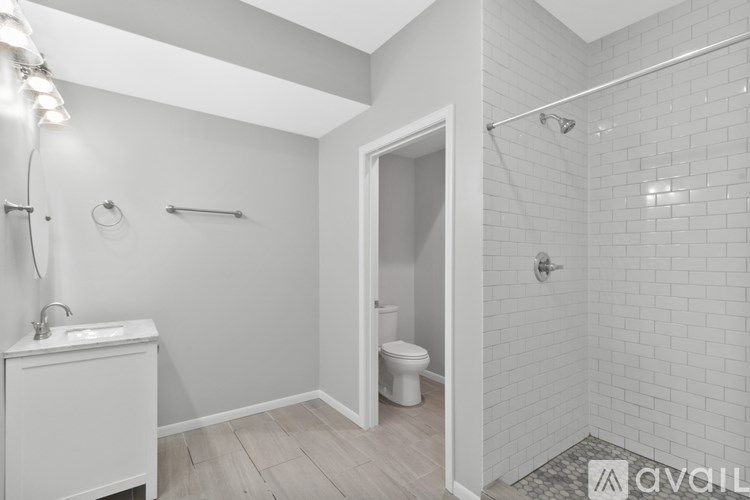 A bathroom with a toilet, sink, and shower.