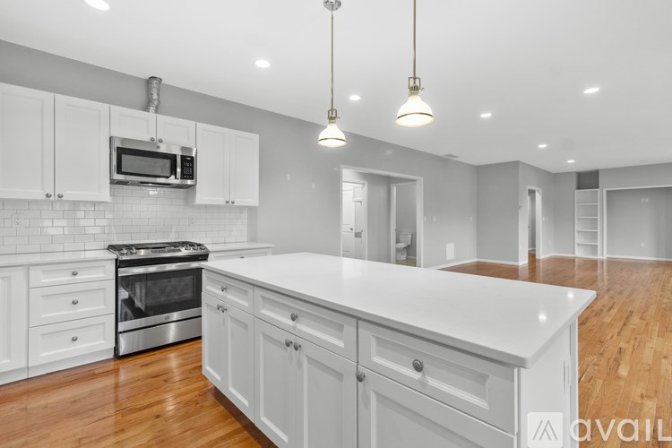 A kitchen with white cabinets and a white island.