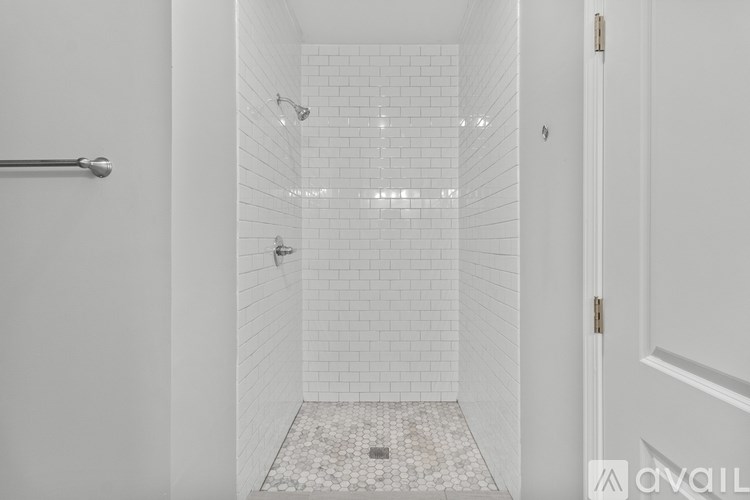 A white tiled bathroom with a walk in shower.