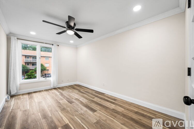 A room with a ceiling fan and wooden flooring.