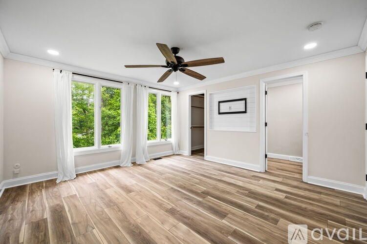 A room with a ceiling fan and wooden flooring.