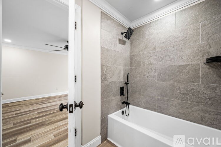 A bathroom with a tub and a door.