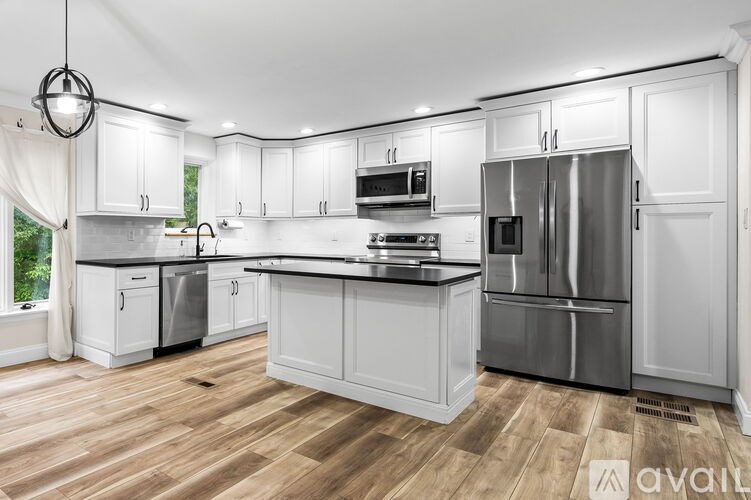A modern kitchen with white cabinets and stainless steel appliances.