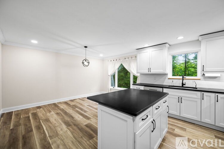 A kitchen with white cabinets and a black countertop.
