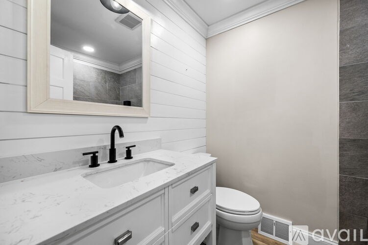 A bathroom with a marble countertop and a white sink.