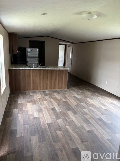 A kitchen area with wooden flooring and a countertop.