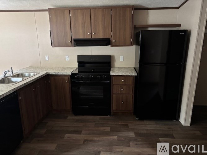 A kitchen with black appliances and wooden cabinets.
