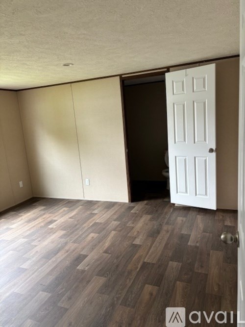 A room with a wooden floor and a white door.